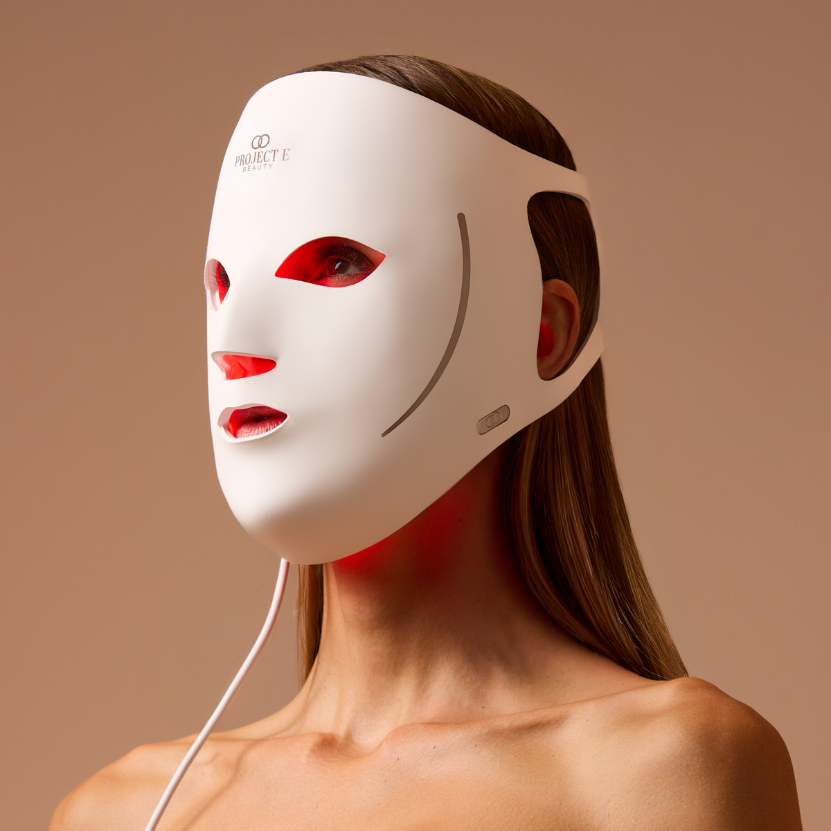 Vrouw met het witte LumaLux Face V2 masker en zichtbaar rood licht aan de binnenkant