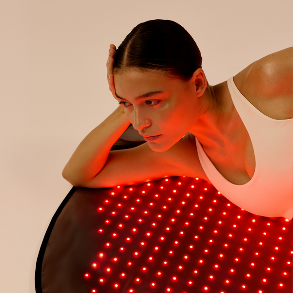 Woman resting on the illuminated Restora LED mat with her arms supporting her upper body