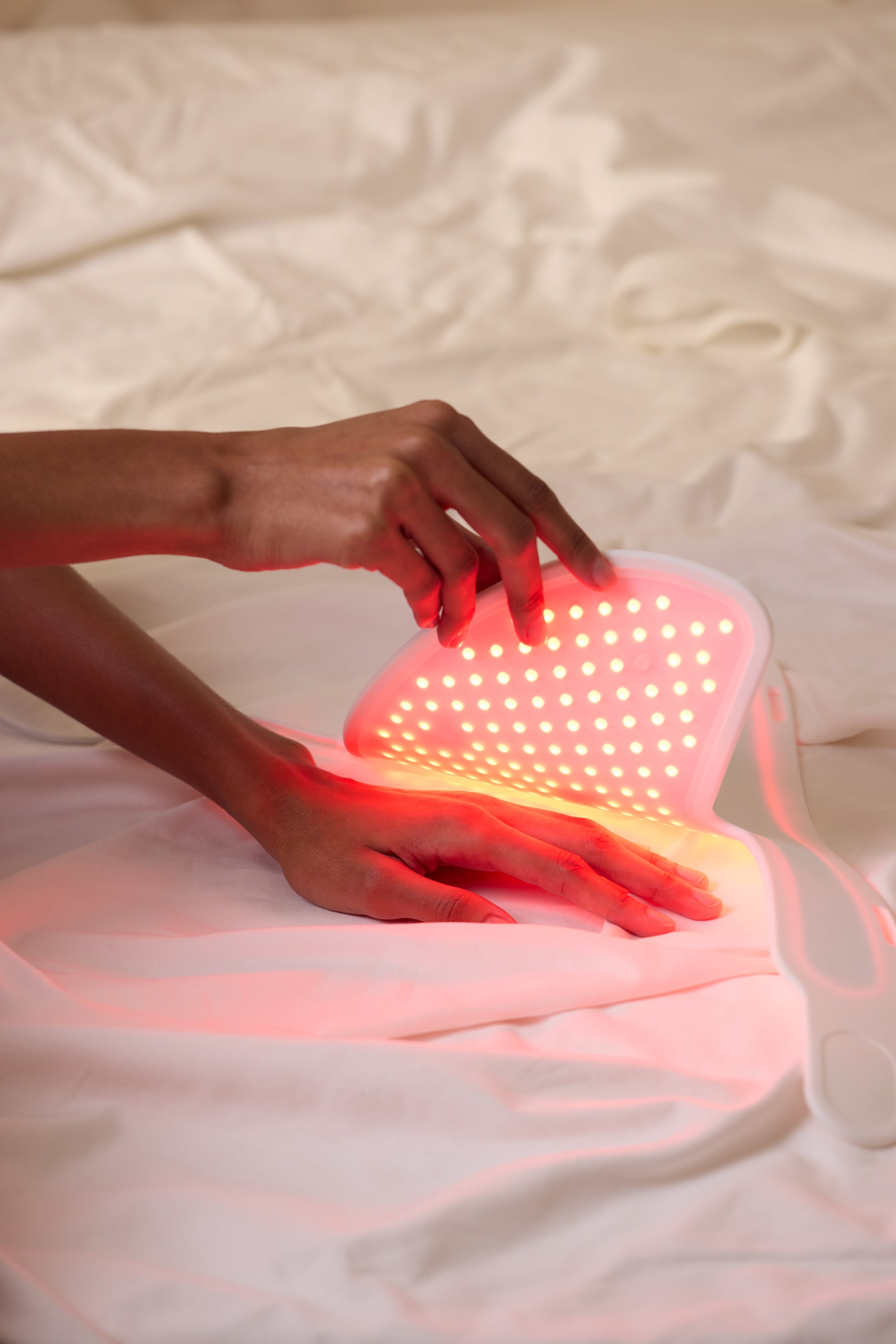 Close-up of female hands under red light device