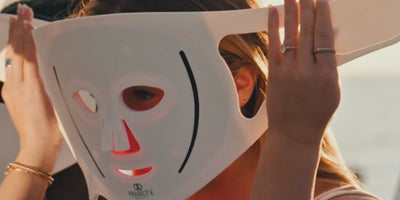 Colleagues enjoying a group skincare wellness activity with LumaLux Pro LED masks at a beach retreat.
